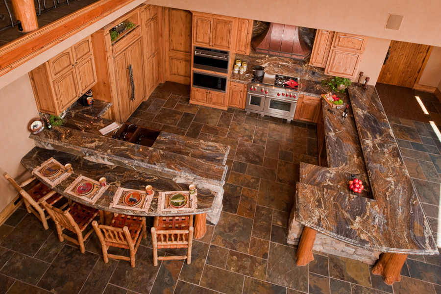 Inredning av ett rustikt mycket stort kök, med en undermonterad diskho, luckor med upphöjd panel, skåp i slitet trä, granitbänkskiva, flerfärgad stänkskydd, stänkskydd i sten, rostfria vitvaror, skiffergolv och en halv köksö
