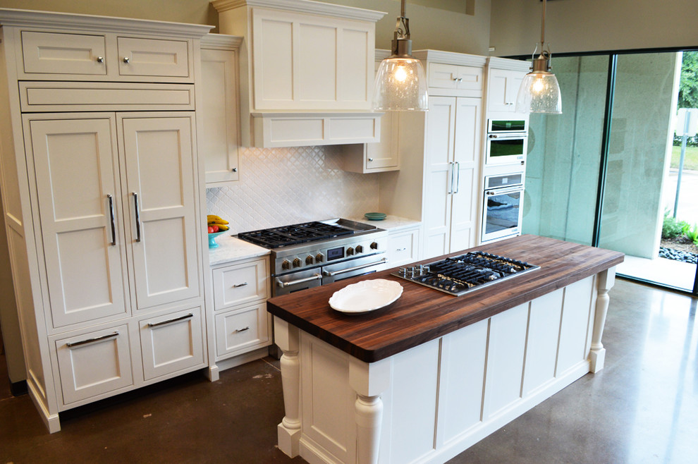 Klassisk inredning av ett linjärt kök och matrum, med luckor med infälld panel, vita skåp, träbänkskiva, vitt stänkskydd och rostfria vitvaror