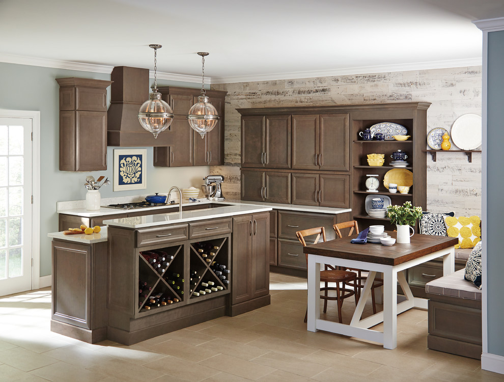 Klassisk inredning av ett mellanstort kök, med en undermonterad diskho, luckor med infälld panel, skåp i mörkt trä, bänkskiva i kvarts, rostfria vitvaror, klinkergolv i keramik och en köksö