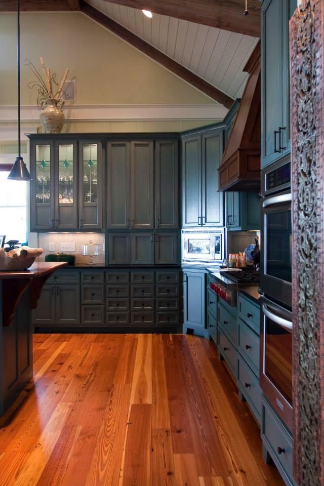 Foto på ett stort vintage linjärt kök, med släta luckor, blå skåp, bänkskiva i onyx, vitt stänkskydd, stänkskydd i tunnelbanekakel, rostfria vitvaror, ljust trägolv och en köksö