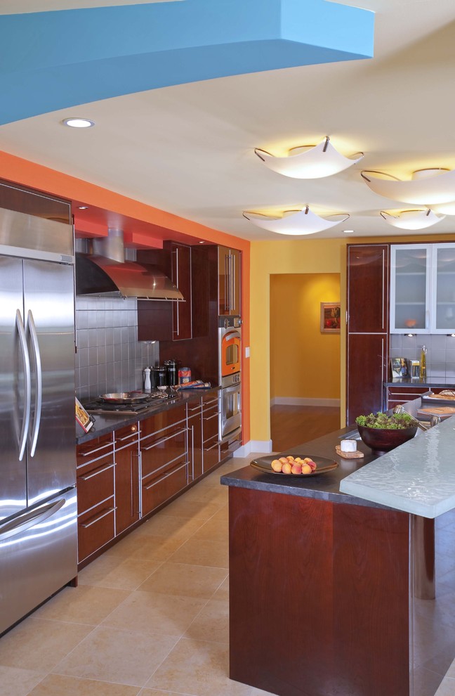 Immagine di una cucina design con ante lisce, elettrodomestici in acciaio inossidabile, ante marroni, paraspruzzi a effetto metallico e paraspruzzi con piastrelle di metallo