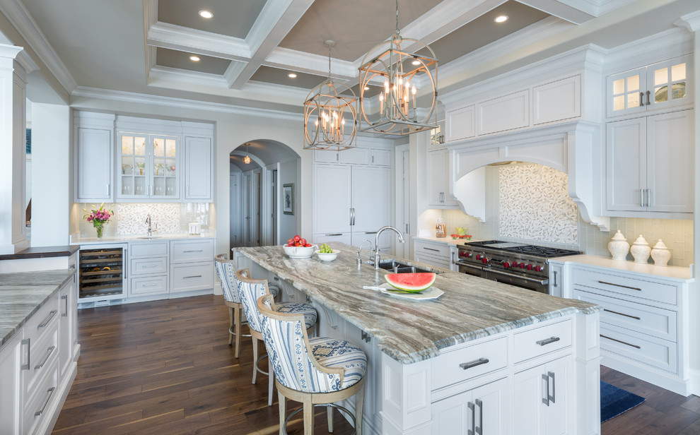 Example of a transitional galley medium tone wood floor kitchen design in Tampa with a double-bowl sink, shaker cabinets, white cabinets, gray backsplash, stainless steel appliances and an island