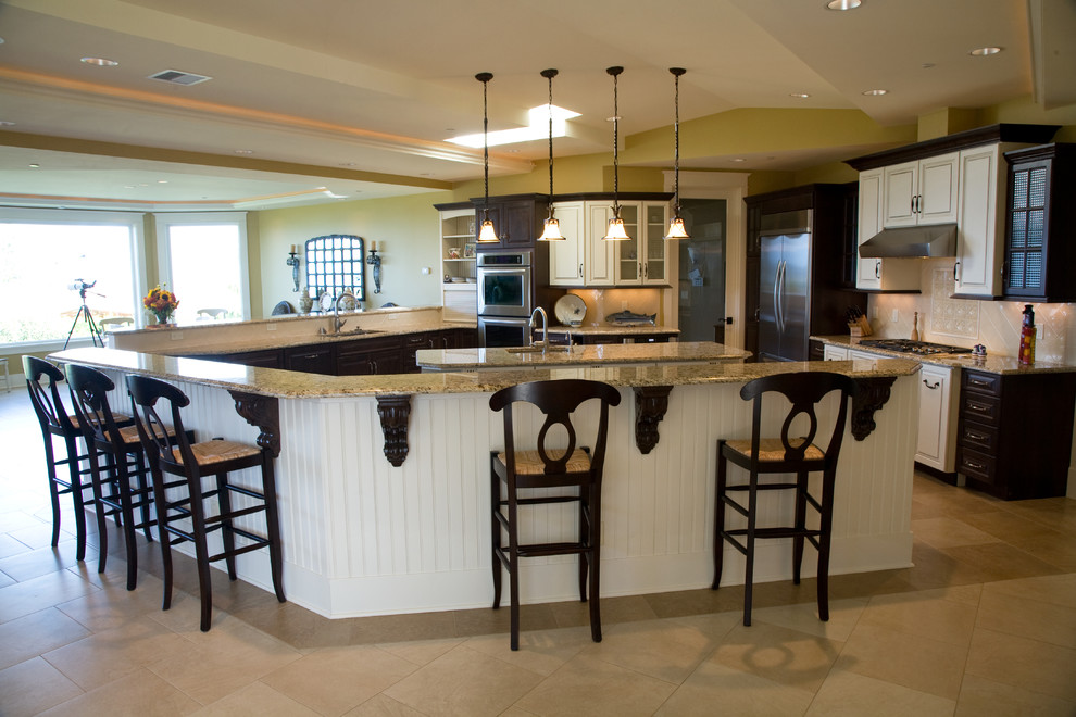 シアトルにある巨大なトラディショナルスタイルのおしゃれなキッチン (シングルシンク、レイズドパネル扉のキャビネット、白いキャビネット、御影石カウンター、白いキッチンパネル、セラミックタイルのキッチンパネル、シルバーの調理設備、トラバーチンの床) の写真
