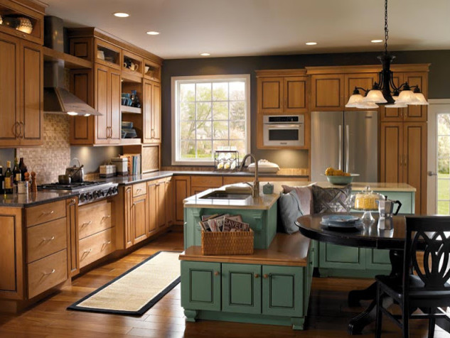 Inspiration for a large timeless l-shaped medium tone wood floor kitchen remodel in Detroit with a double-bowl sink, raised-panel cabinets, distressed cabinets, granite countertops, beige backsplash, ceramic backsplash, stainless steel appliances and an island