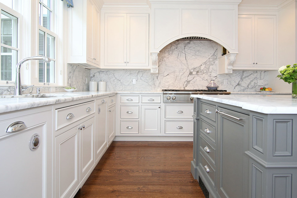 Foto på ett vintage kök, med vita skåp, marmorbänkskiva, vitt stänkskydd, rostfria vitvaror, mörkt trägolv och en köksö