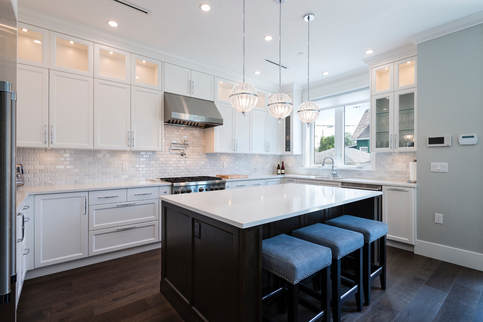 Inspiration for a medium sized traditional u-shaped open plan kitchen in Vancouver with a submerged sink, recessed-panel cabinets, white cabinets, engineered stone countertops, grey splashback, marble splashback, stainless steel appliances, dark hardwood flooring, an island and brown floors.
