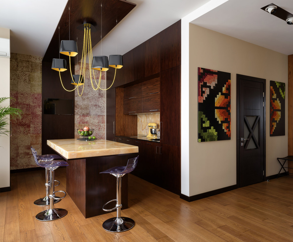 Пример оригинального дизайна: параллельная кухня-гостиная среднего размера в современном стиле с плоскими фасадами, темными деревянными фасадами, столешницей из оникса, желтым фартуком, паркетным полом среднего тона, островом, желтой столешницей, техникой под мебельный фасад и коричневым полом
