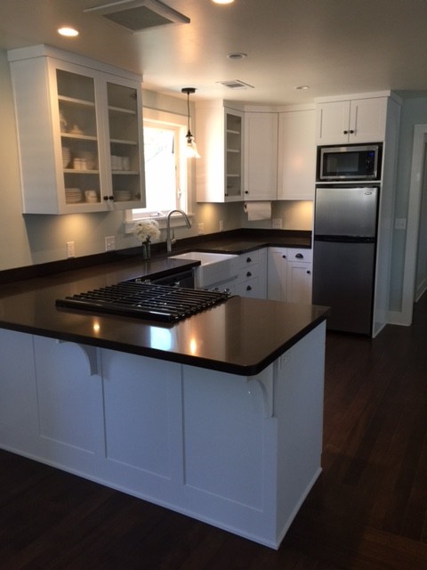 Small transitional kitchen photo in New York with a farmhouse sink, shaker cabinets, white cabinets, quartz countertops and stainless steel appliances
