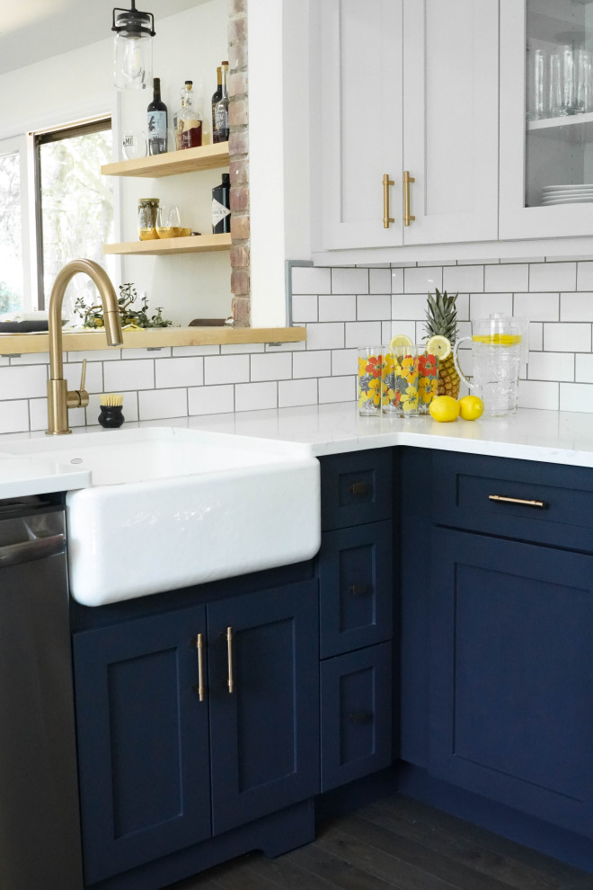 Eat-in kitchen - mid-sized eclectic l-shaped eat-in kitchen idea in Detroit with a farmhouse sink, shaker cabinets, blue cabinets, orange backsplash, ceramic backsplash, stainless steel appliances, a peninsula and white countertops