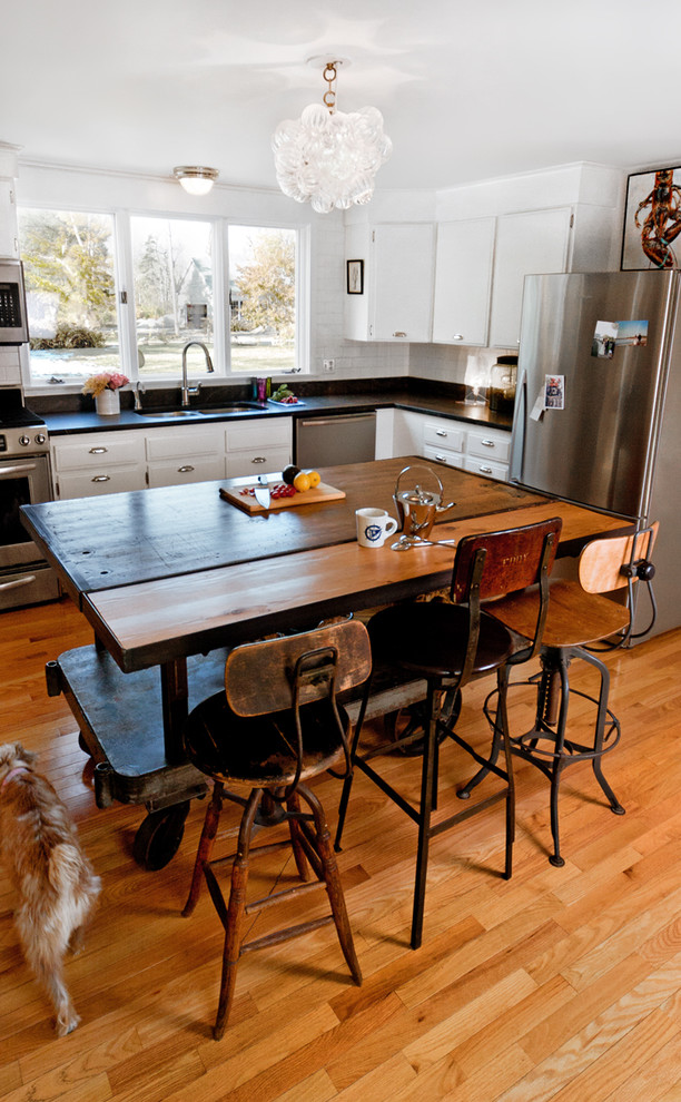 Eklektische Küche in L-Form mit weißen Schränken, Küchengeräten aus Edelstahl und Mauersteinen in Portland Maine