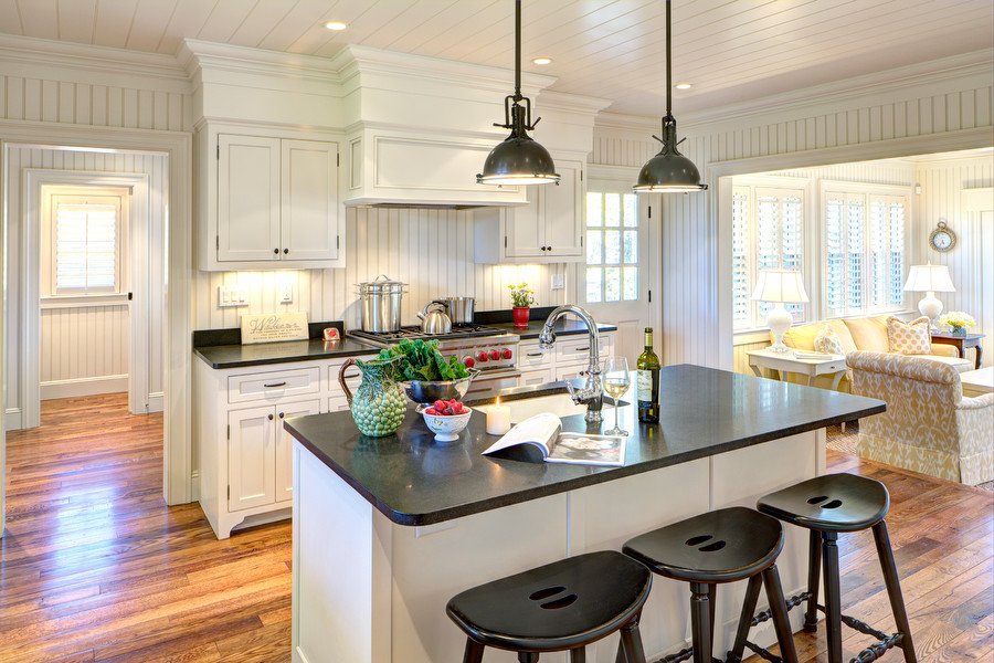 Foto på ett mellanstort vintage linjärt kök med öppen planlösning, med en undermonterad diskho, luckor med profilerade fronter, vita skåp, granitbänkskiva, rostfria vitvaror, mellanmörkt trägolv och en köksö
