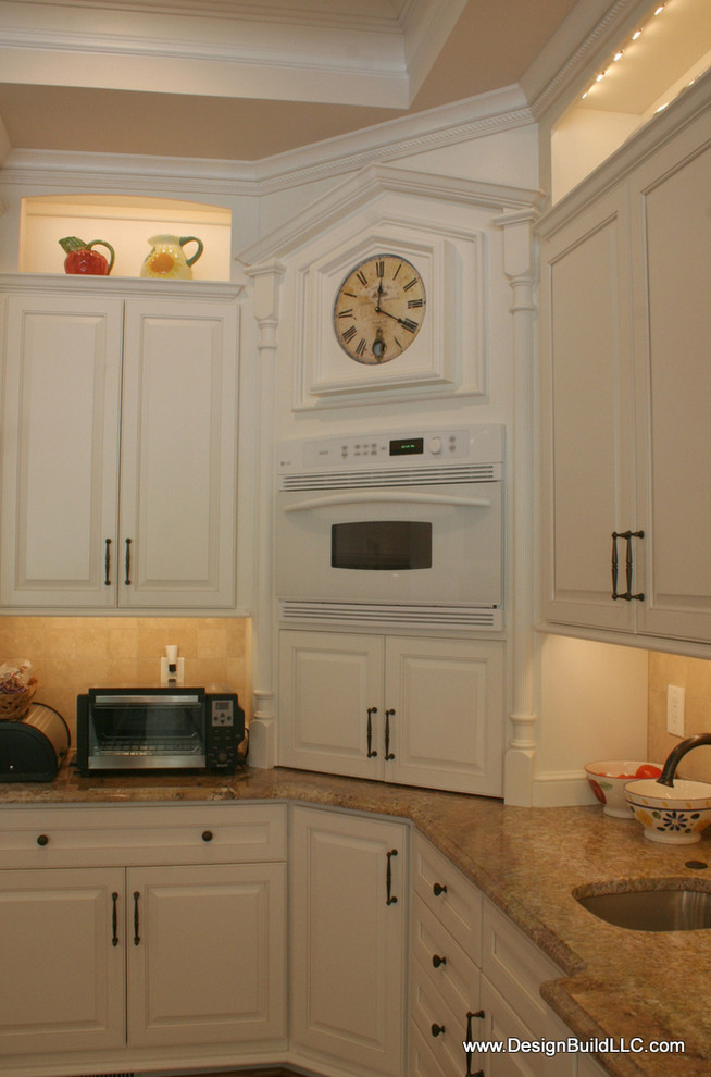 Inspiration för stora klassiska kök, med en undermonterad diskho, luckor med upphöjd panel, vita skåp, granitbänkskiva, beige stänkskydd, stänkskydd i stenkakel, rostfria vitvaror, mellanmörkt trägolv, en köksö och brunt golv