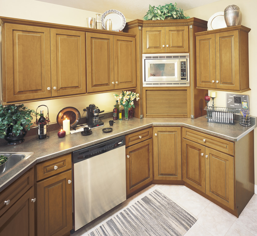 Mid-sized transitional u-shaped enclosed kitchen photo in Other with raised-panel cabinets, medium tone wood cabinets, stainless steel appliances and a peninsula