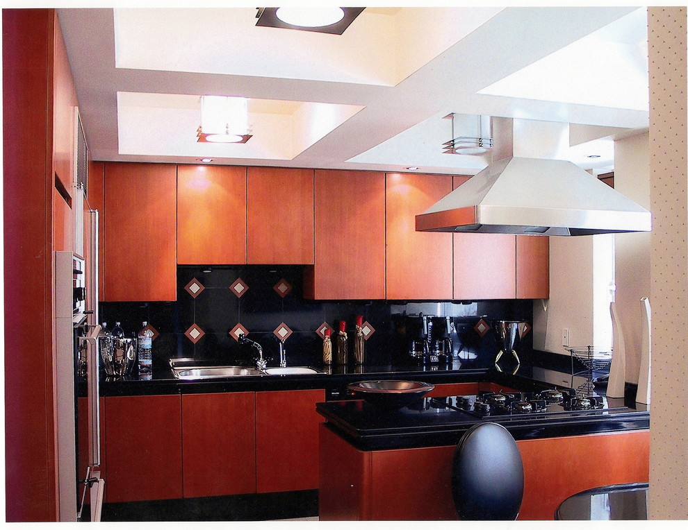 Modern inredning av ett mycket stort kök, med en dubbel diskho, släta luckor, skåp i mellenmörkt trä, granitbänkskiva, flerfärgad stänkskydd, stänkskydd i stenkakel, svarta vitvaror och kalkstensgolv