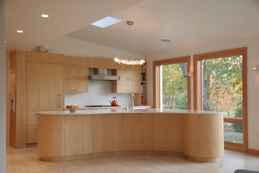 Foto de cocina contemporánea con armarios con paneles lisos, puertas de armario de madera clara, salpicadero blanco y electrodomésticos con paneles