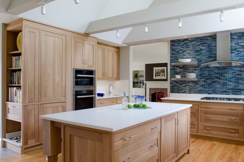 Large minimalist u-shaped light wood floor and brown floor eat-in kitchen photo in Boston with quartz countertops, glass tile backsplash, paneled appliances, an island, an undermount sink, shaker cabinets, light wood cabinets, blue backsplash and white countertops