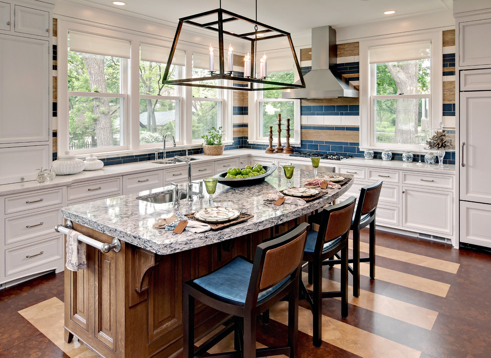 Kitchen - mid-sized transitional l-shaped brown floor kitchen idea in Minneapolis with a double-bowl sink, raised-panel cabinets, white cabinets, granite countertops, blue backsplash, subway tile backsplash, paneled appliances and an island