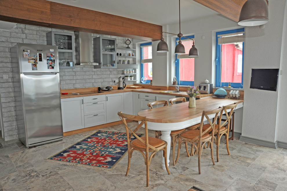 Exempel på ett litet maritimt kök, med en enkel diskho, öppna hyllor, vita skåp, bänkskiva i zink, travertin golv och en köksö