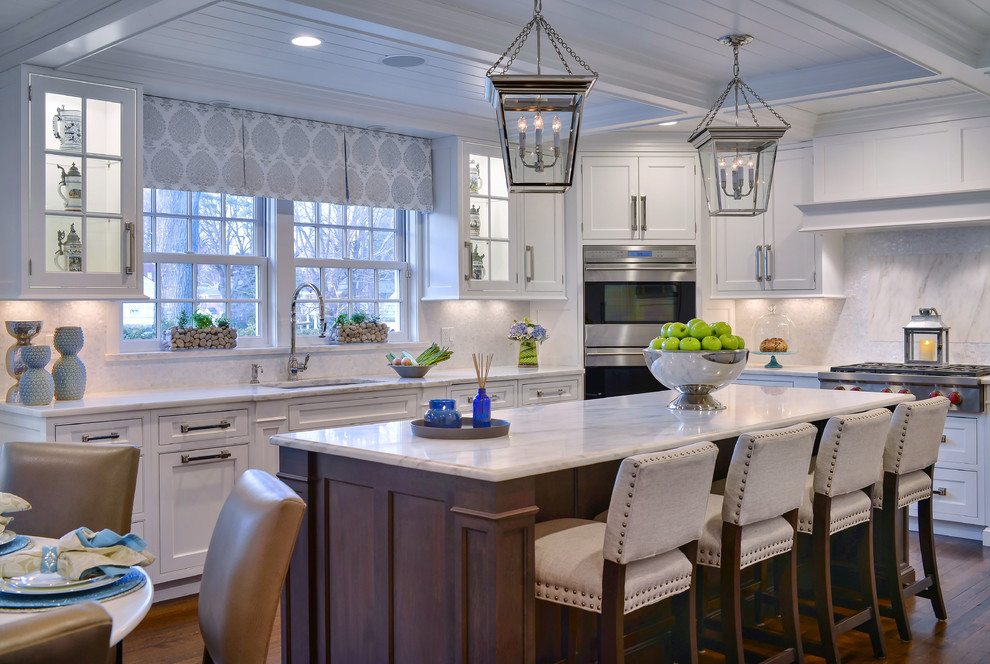 Large transitional dark wood floor eat-in kitchen photo in New York with white cabinets, marble countertops, white backsplash, stainless steel appliances and an island