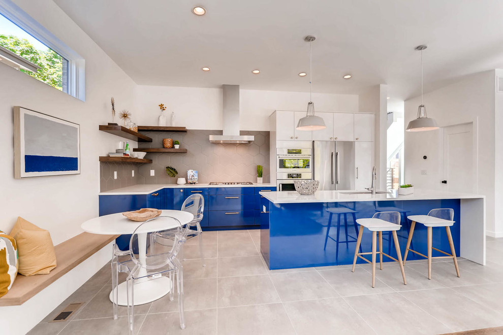 Foto de cocina lineal contemporánea abierta con fregadero bajoencimera, armarios con paneles lisos, puertas de armario azules, salpicadero verde, una isla y encimeras blancas