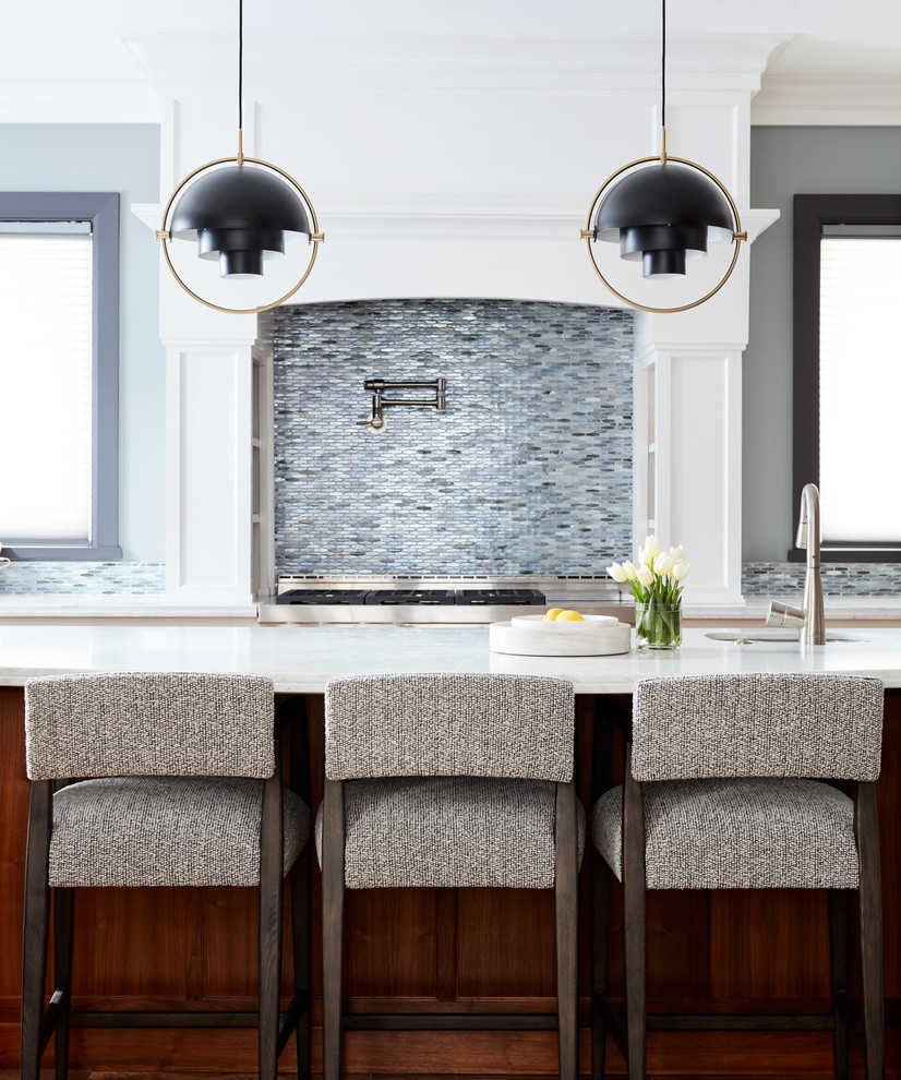 На фото: п-образная кухня среднего размера в современном стиле с столешницей из кварцевого агломерата, синим фартуком, фартуком из стеклянной плитки, островом и врезной мойкой