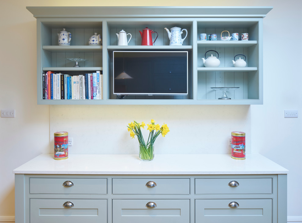 Photo of a large classic l-shaped open plan kitchen in London with a double-bowl sink, recessed-panel cabinets, grey cabinets, composite countertops, white splashback, stainless steel appliances, medium hardwood flooring and multiple islands.