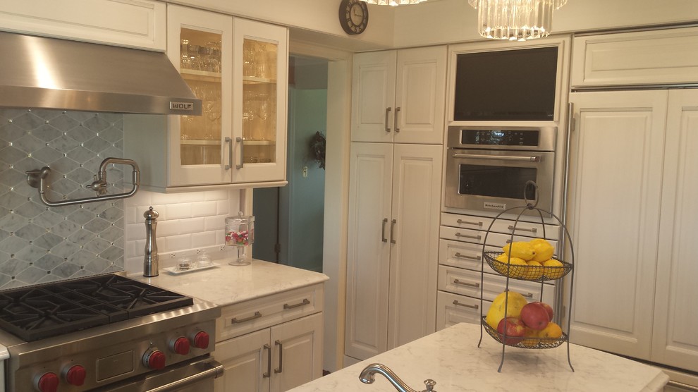 Small traditional u-shaped kitchen/diner in Other with a submerged sink, raised-panel cabinets, white cabinets, marble worktops, white splashback, metro tiled splashback, stainless steel appliances, ceramic flooring and an island.