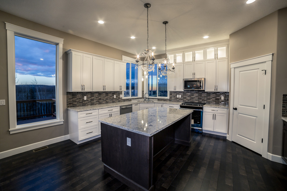 Example of a mid-sized classic l-shaped dark wood floor and brown floor eat-in kitchen design in Other with an undermount sink, shaker cabinets, white cabinets, granite countertops, multicolored backsplash, matchstick tile backsplash, stainless steel appliances, an island and gray countertops
