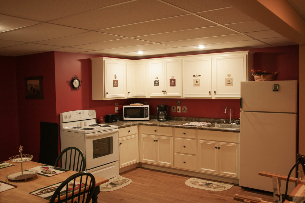 Exempel på ett mellanstort klassiskt kök, med laminatgolv, brunt golv, en enkel diskho, luckor med upphöjd panel, vita skåp, rött stänkskydd, rostfria vitvaror och bänkskiva i kvarts
