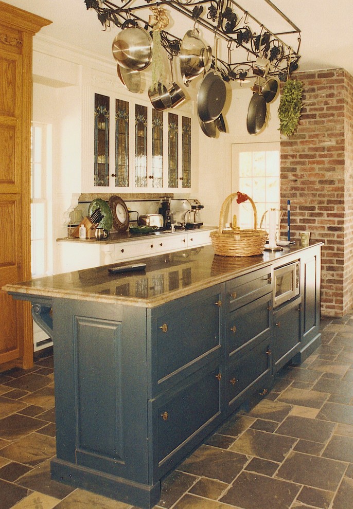 Modelo de cocina campestre de tamaño medio con armarios estilo shaker, puertas de armario azules, suelo de pizarra y una isla