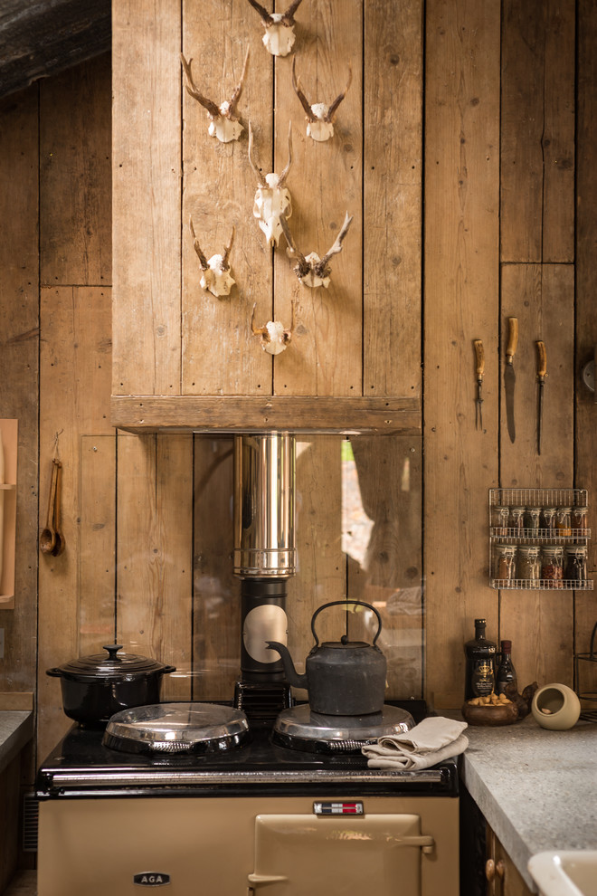 Inspiration for a small rustic galley kitchen/diner in Cornwall with a belfast sink, medium wood cabinets, integrated appliances, medium hardwood flooring and concrete worktops.