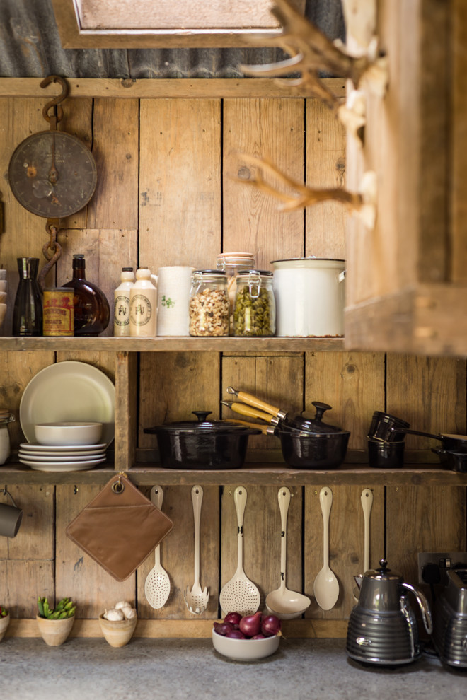Foto di una piccola cucina abitabile stile rurale con lavello stile country, ante in legno scuro, elettrodomestici da incasso, pavimento in legno massello medio e top in cemento