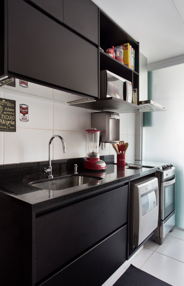 Kleine, Einzeilige Moderne Küche mit Unterbauwaschbecken, flächenbündigen Schrankfronten, Küchenrückwand in Weiß und Küchengeräten aus Edelstahl in Sonstige
