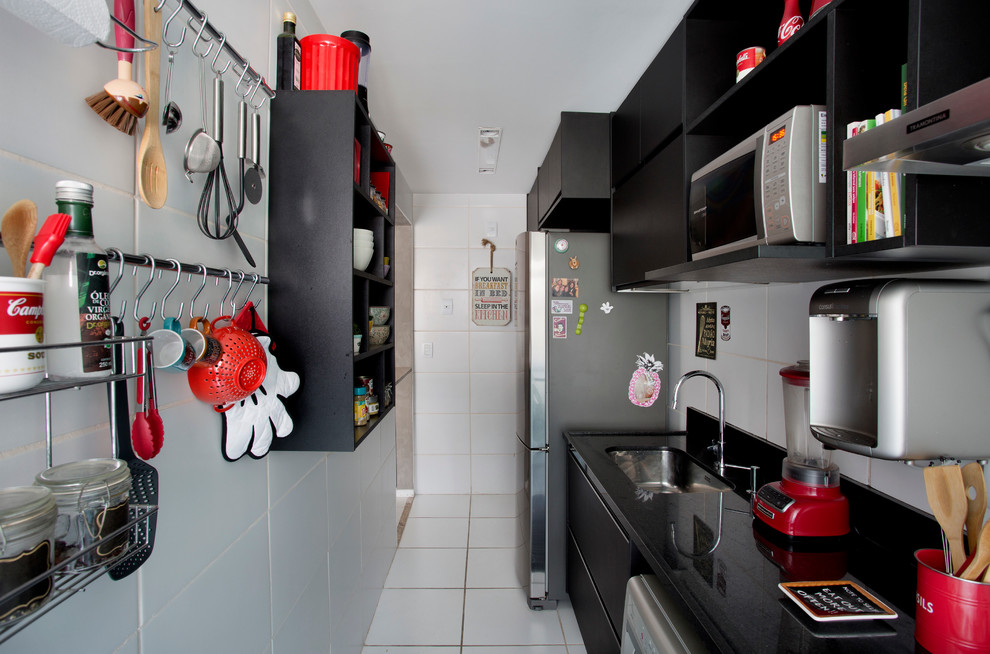 Kleine Moderne Küche mit schwarzen Schränken in Sonstige