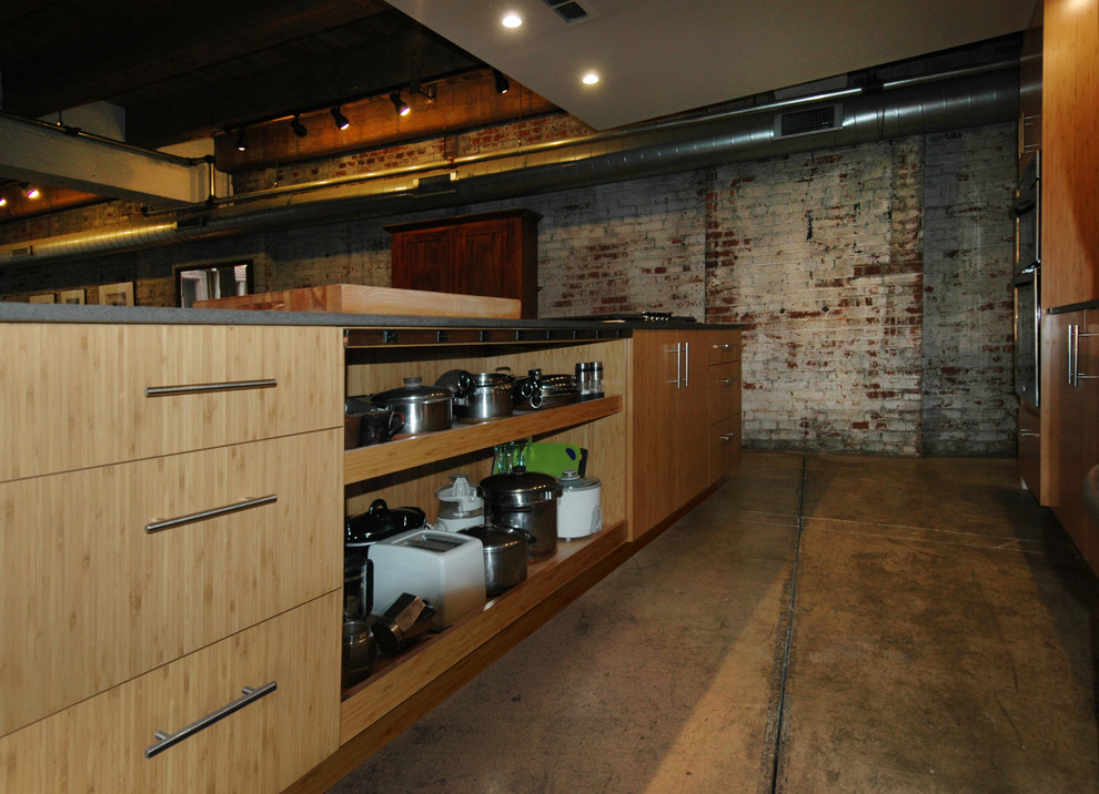 Photo of a medium sized industrial single-wall kitchen/diner in Other with a double-bowl sink, flat-panel cabinets, light wood cabinets, engineered stone countertops, red splashback, glass sheet splashback, stainless steel appliances, concrete flooring and an island.