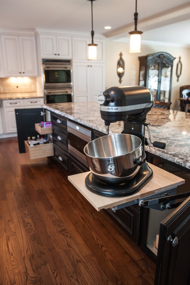 Example of a large classic l-shaped dark wood floor eat-in kitchen design in New York with a farmhouse sink, raised-panel cabinets, white cabinets, granite countertops, multicolored backsplash, mosaic tile backsplash, stainless steel appliances and an island