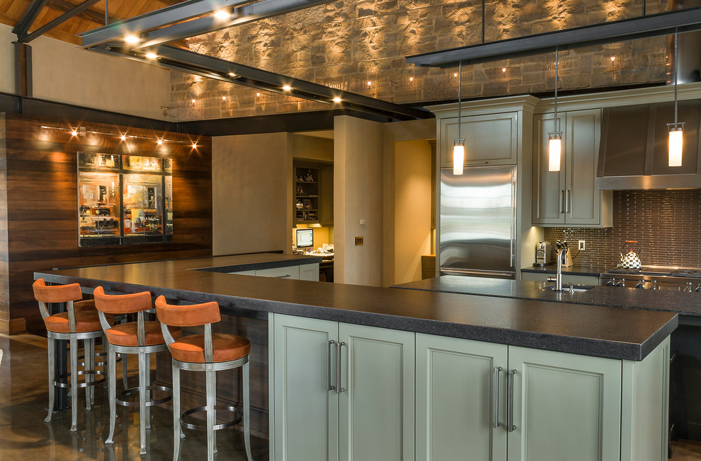 シカゴにある高級な広いトランジショナルスタイルのおしゃれなキッチン (シングルシンク、フラットパネル扉のキャビネット、グレーのキャビネット、御影石カウンター、茶色いキッチンパネル、セラミックタイルのキッチンパネル、シルバーの調理設備、コンクリートの床) の写真