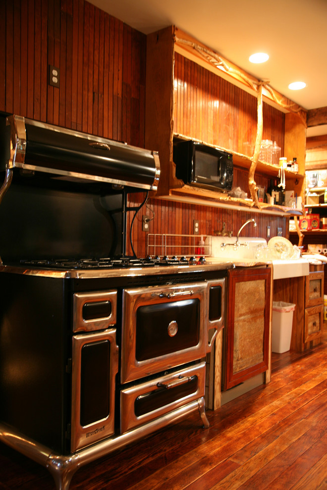 Offene, Zweizeilige, Mittelgroße Klassische Küche mit Landhausspüle, offenen Schränken, hellbraunen Holzschränken, Arbeitsplatte aus Holz, schwarzen Elektrogeräten, dunklem Holzboden und Kücheninsel in Baltimore