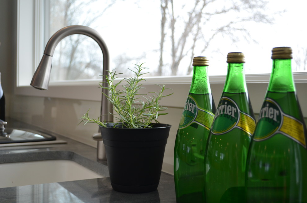 Idée de décoration pour une grande cuisine américaine design en L et bois brun avec un évier encastré, un placard à porte vitrée, un plan de travail en granite, une crédence blanche, une crédence en feuille de verre, un électroménager en acier inoxydable, parquet foncé et îlot.