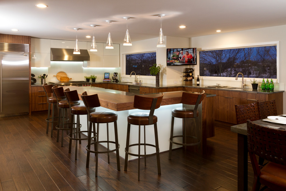 Photo of a large contemporary l-shaped kitchen/diner in Minneapolis with a submerged sink, flat-panel cabinets, medium wood cabinets, granite worktops, white splashback, glass sheet splashback, stainless steel appliances, dark hardwood flooring and an island.