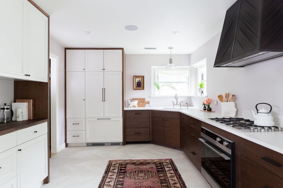 Inspiration for a large scandinavian u-shaped light wood floor and white floor enclosed kitchen remodel in Atlanta with an integrated sink, recessed-panel cabinets, dark wood cabinets, solid surface countertops, paneled appliances, no island and white countertops