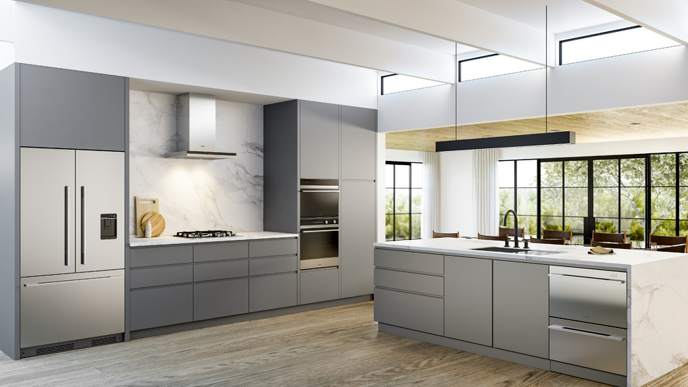 This is an example of a large contemporary open plan kitchen in Buckinghamshire with a built-in sink, flat-panel cabinets, grey cabinets, marble worktops, marble splashback, stainless steel appliances, light hardwood flooring and an island.