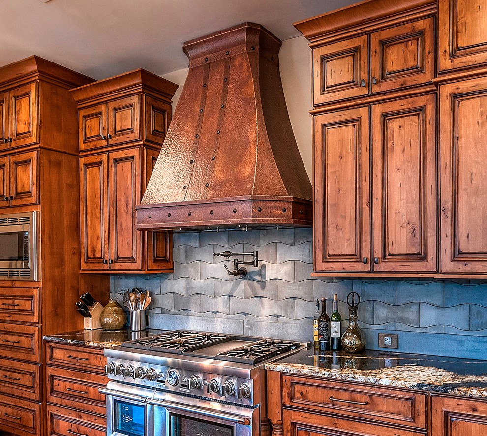 Foto di una grande cucina rustica con lavello integrato, ante con bugna sagomata, ante in legno scuro, elettrodomestici in acciaio inossidabile e pavimento in legno massello medio