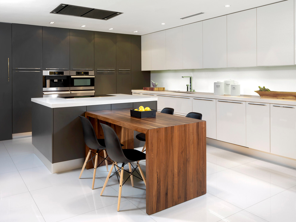 This is an example of a contemporary l-shaped kitchen/diner in Miami with a submerged sink, flat-panel cabinets, white cabinets, white splashback, stainless steel appliances and an island.