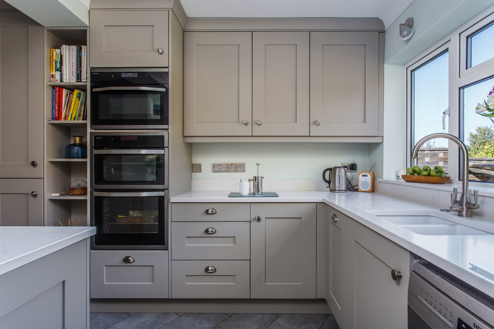 Inspiration for a small classic u-shaped kitchen/diner in Kent with shaker cabinets, grey cabinets, quartz worktops, white splashback, stone slab splashback, stainless steel appliances, slate flooring, no island, grey floors and white worktops.