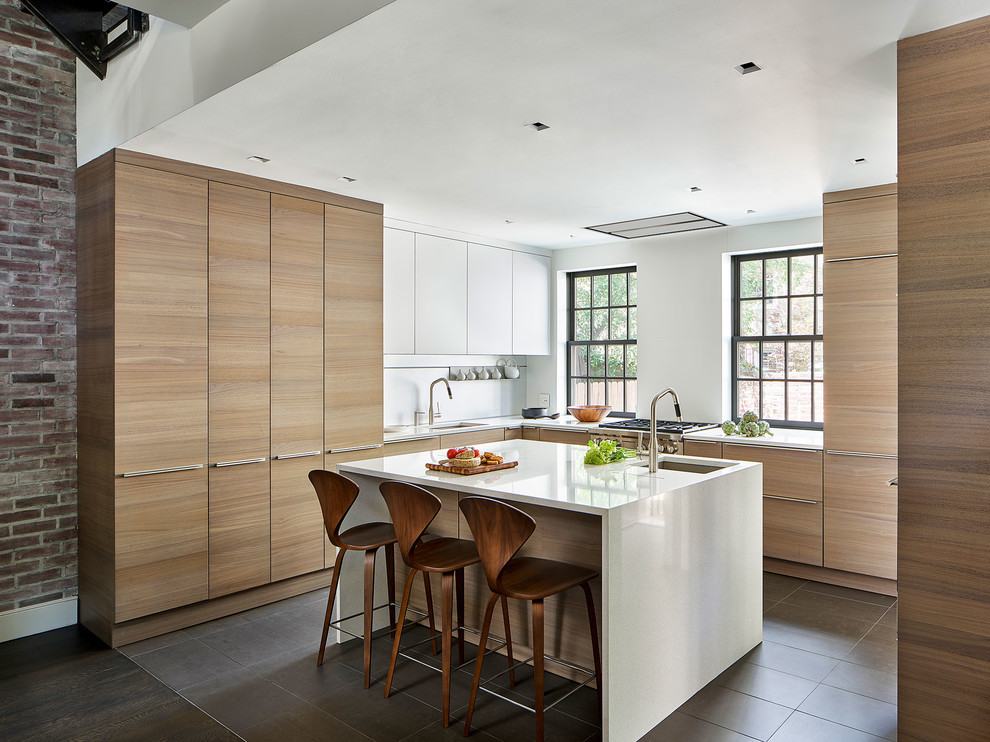 Inspiration for a contemporary u-shaped kitchen in Philadelphia with a submerged sink, flat-panel cabinets, light wood cabinets, an island, grey floors and white worktops.