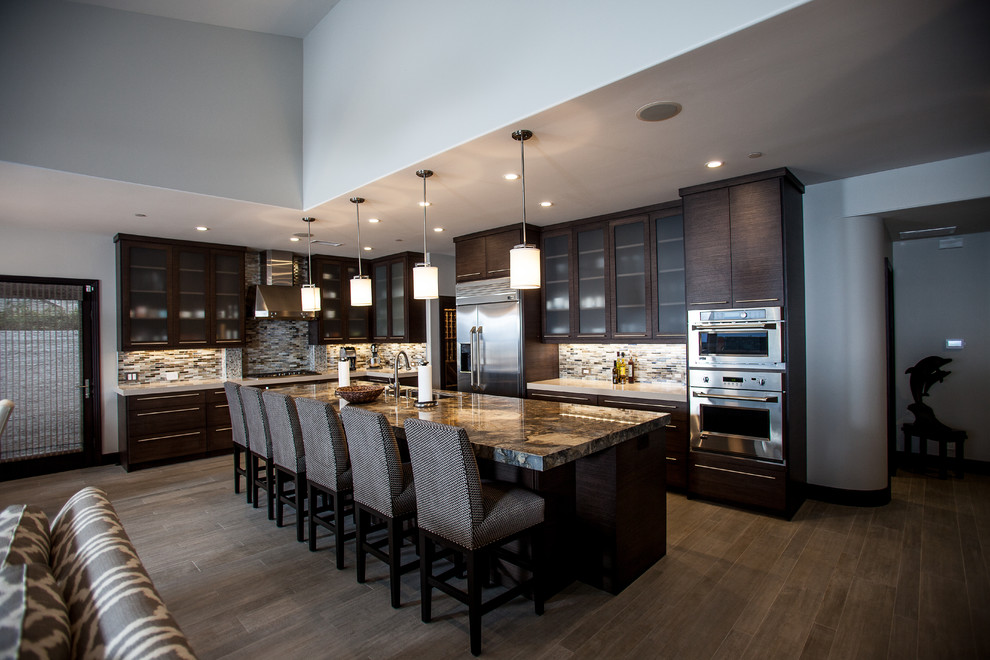 Inspiration for a large contemporary l-shaped dark wood floor and brown floor open concept kitchen remodel in Los Angeles with an undermount sink, glass-front cabinets, dark wood cabinets, granite countertops, multicolored backsplash, stone tile backsplash, stainless steel appliances and an island