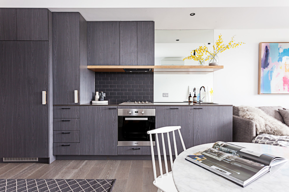This is an example of a small contemporary kitchen in Melbourne with medium hardwood flooring.