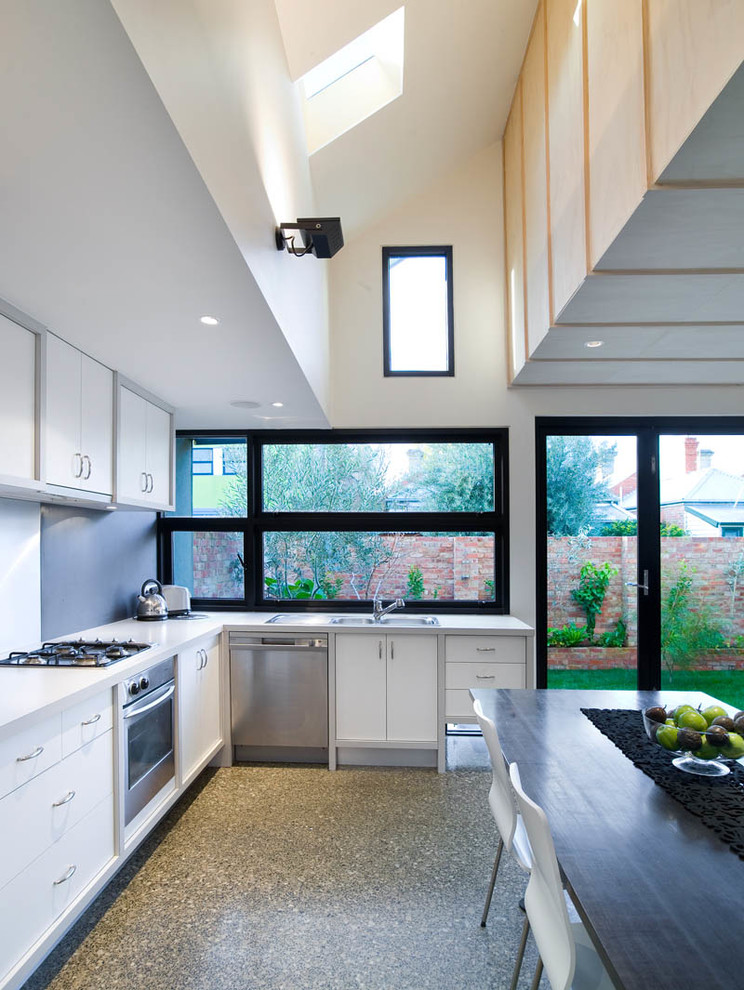 Moderne Wohnküche mit weißen Schränken und grauem Boden in Melbourne
