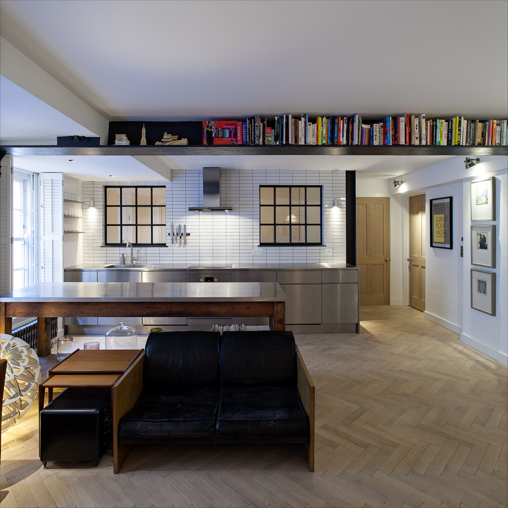 Example of an urban single-wall kitchen design in London with stainless steel countertops